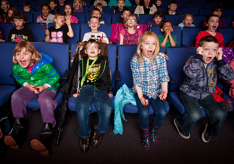 Young children watching a thrilling movie