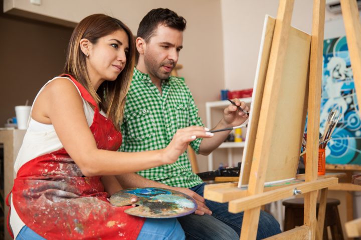 Couple painting together on canvas for date night in grande prairie