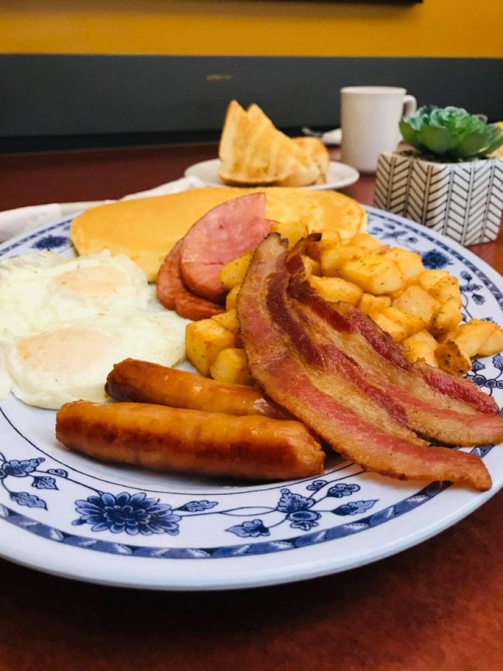 full breakfast spread with eggs, bacon, potatoes, ham, and sausage