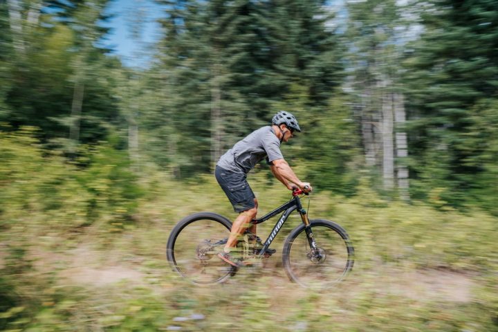 man cycling through forest