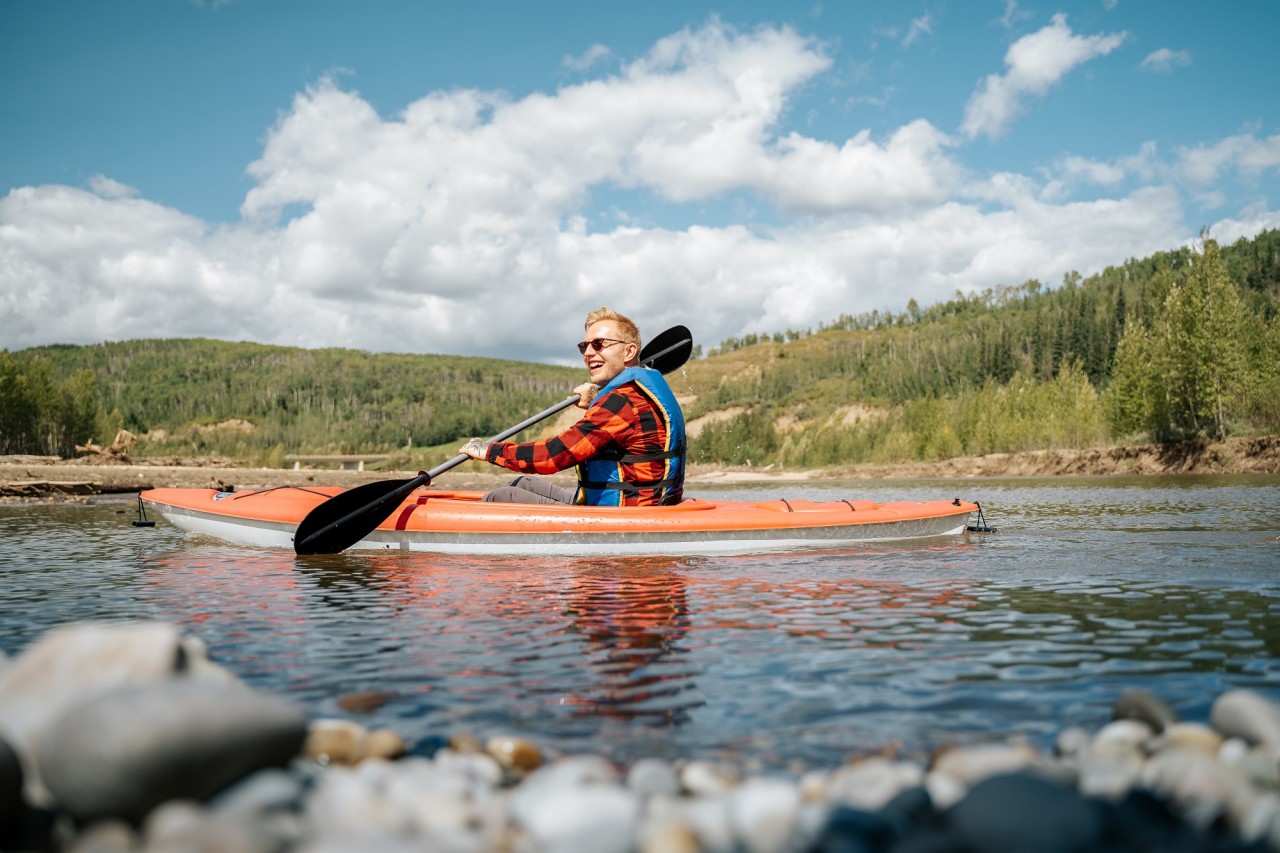 Man happily kayaking down a river